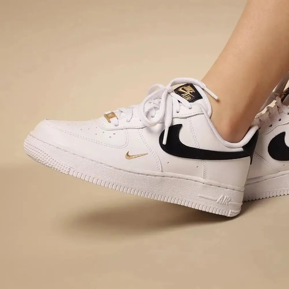 Air Force 1 Low ’07 Essential Mini Swoosh 'White Black Gold' worn on foot, showcasing stylish design, premium materials, and comfortable fit.