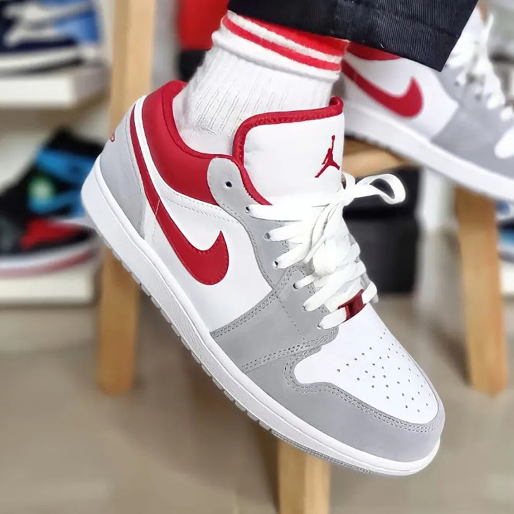 Jordan 1 Low Light Smoke 'Grey Red' worn on foot, displaying its stylish colorway, comfortable fit, and iconic design for everyday wear.