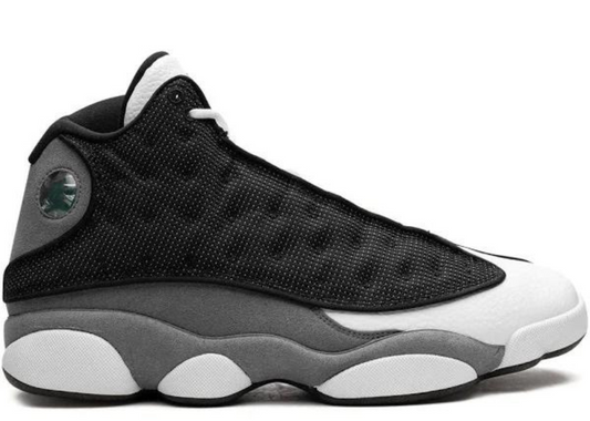 Air Jordan 13 'Black Flint' sneaker in black, white, and grey with premium materials and signature holographic emblem. Limited stock available.