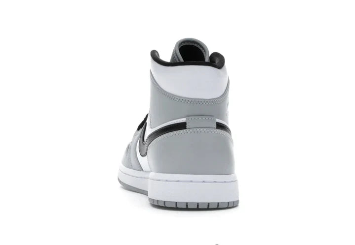 Rear view of the Jordan 1 Mid 'Light Smoke Grey' sneaker, displaying the grey and white leather panels, black collar, and sturdy rubber outsole.