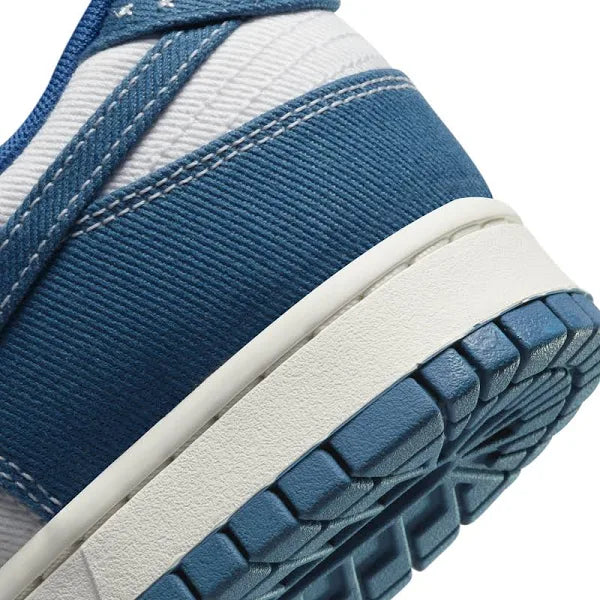 Close-up of Nike Dunk Low ‘Industrial Blue’ heel, highlighting textured denim material, contrast stitching, and sturdy white midsole for lasting comfort.