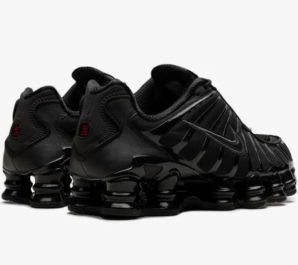 Rear view of Nike Shox TL 'Black Max' showcasing sleek black design with red accents and signature Shox cushioning. Stylish and comfortable.