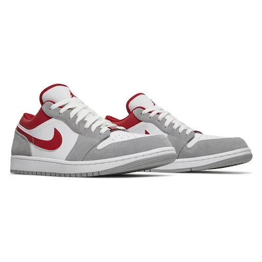 Pair of Jordan 1 Low Light Smoke 'Grey Red' sneakers showcasing premium materials, a sleek low-top silhouette, and a bold red Swoosh design.