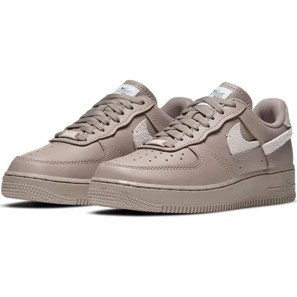 Pair of Nike Air Force 1 Low LXX 'Malt' sneakers featuring a refined beige leather upper, suede accents, and signature Air cushioning for all-day wear.